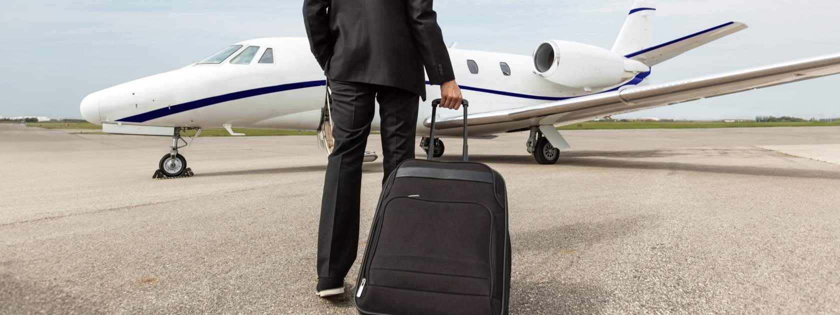 Man with suitcase in front of jet