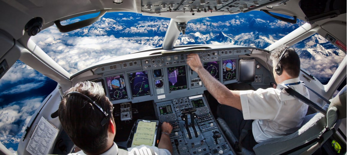 Pilots at the controls of a large aircraft.