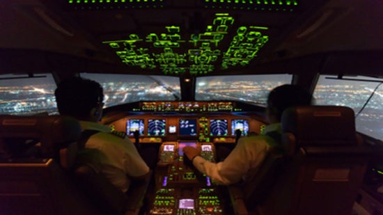 View from inside the cockpit of a large plane with the sun visible through the windows.