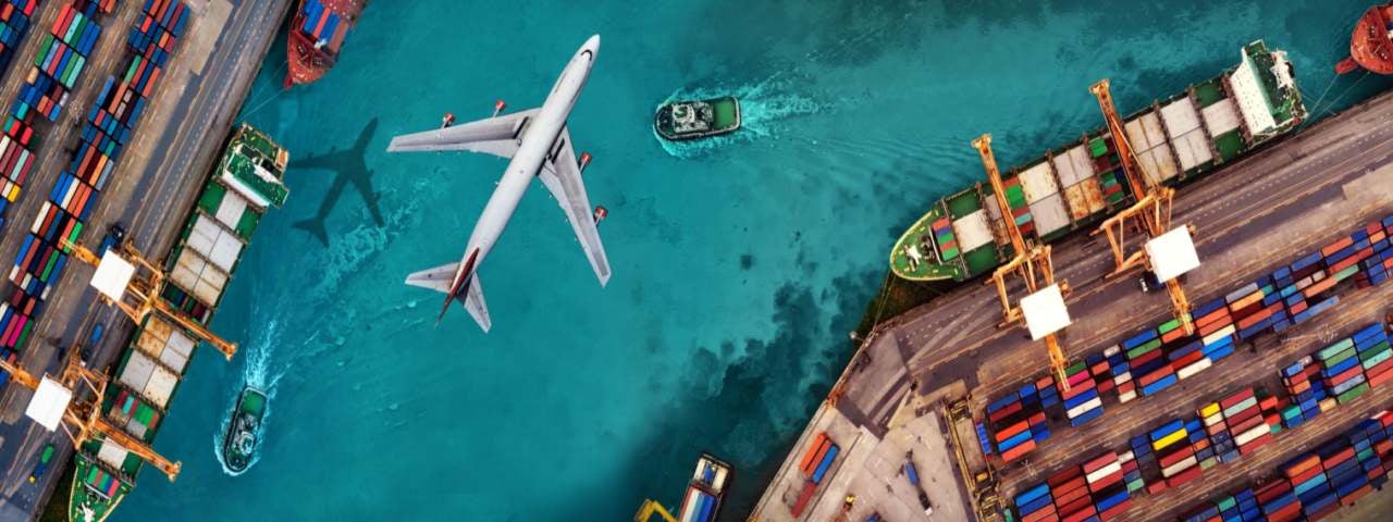 A commercial airplane fly above the cargo ports.