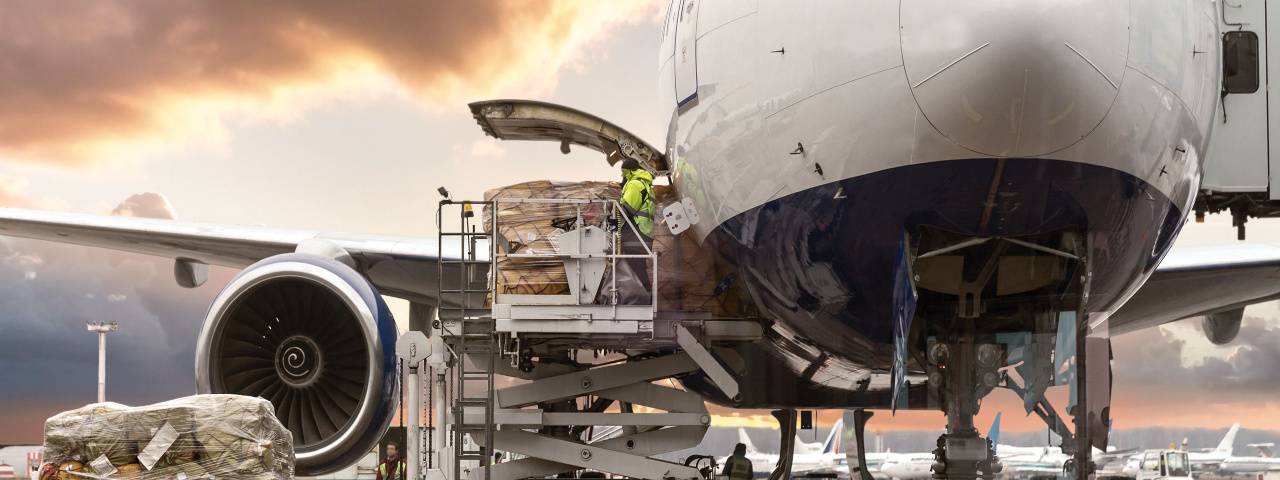 Cargo being loaded into airplane using forklift.