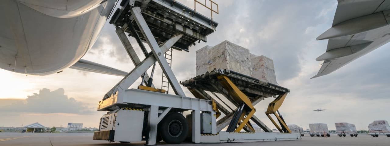 Ground shot perspective of cargo being loaded onto an air cargo plane.