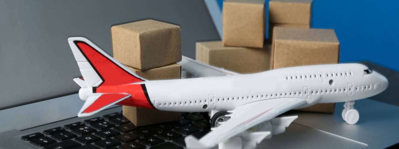 Model airplane on keyboard with freight boxes in background.