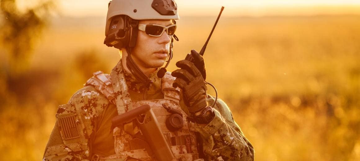 Portrait of young NATO soldier holding a radio station