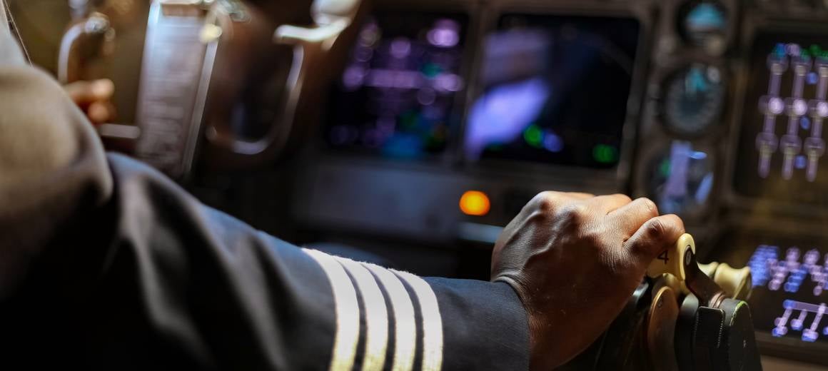 Close up of a pilot’s hand while flying an aircraft.