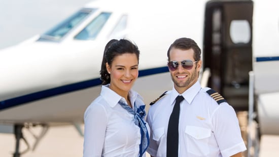 Pilot and cabin crew standing in front of a private jet.