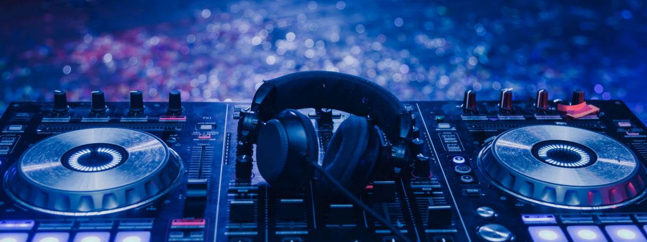 DJ decks under blue lighting with a blurred background.
