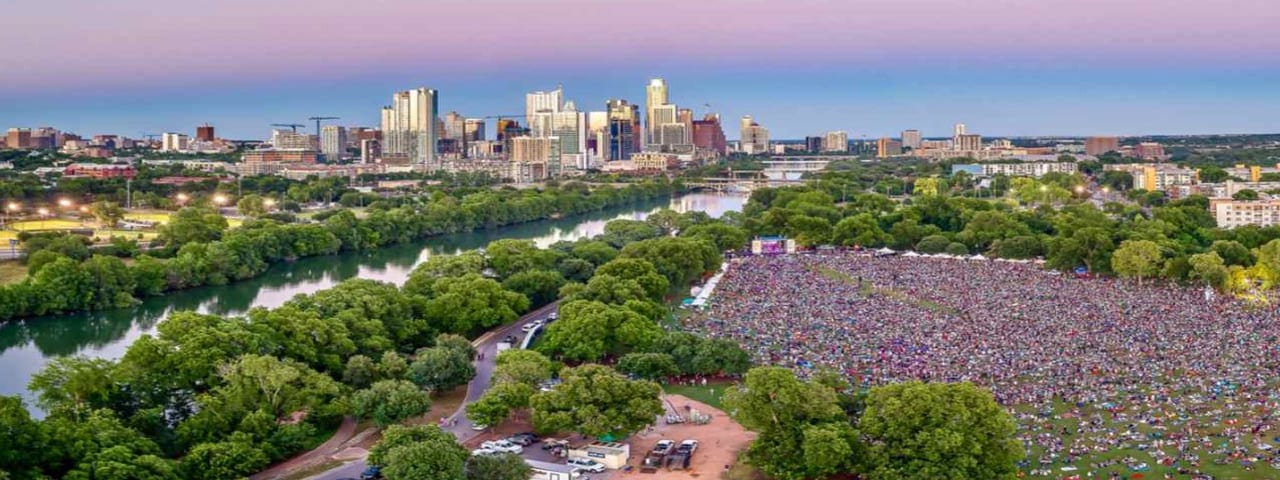 View over Zilker Metropolitan Park during Austin City Limits Music Festival with the city in the background.