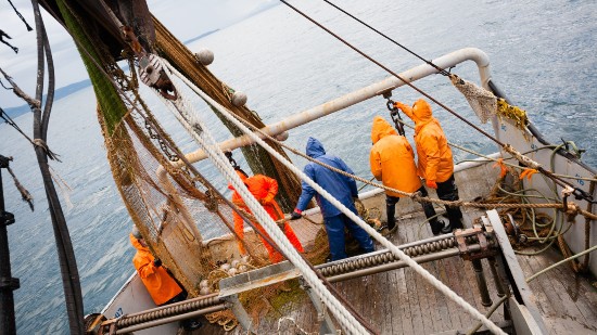 A fishing vessel with workers on the deck.