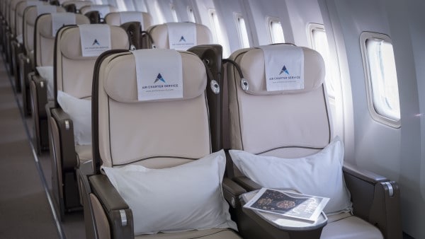 Seats on board a passenger aircraft with Air Charter Service branded headrests.