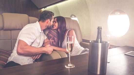 Man and woman on board private jet enjoying champagne