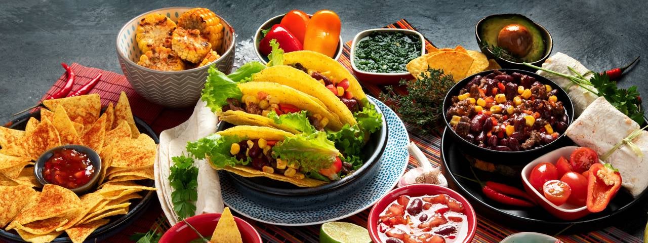 A table with an assortment of Mexican dishes.