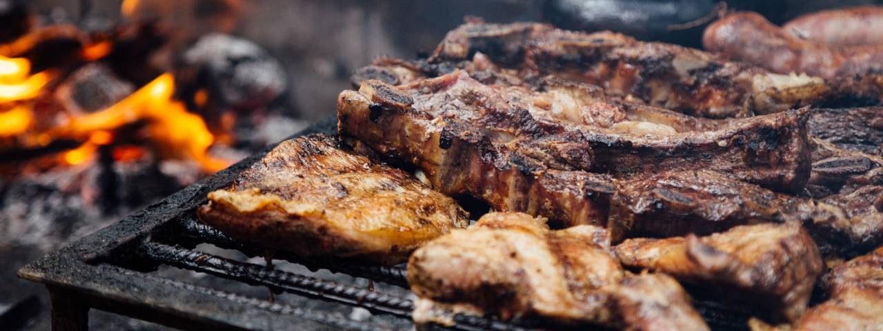 A grill filled with various cuts of meat.