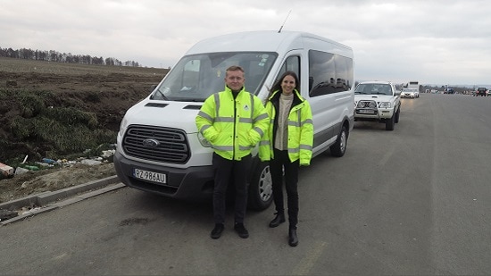 Two ACS staff standing next to a minibus.