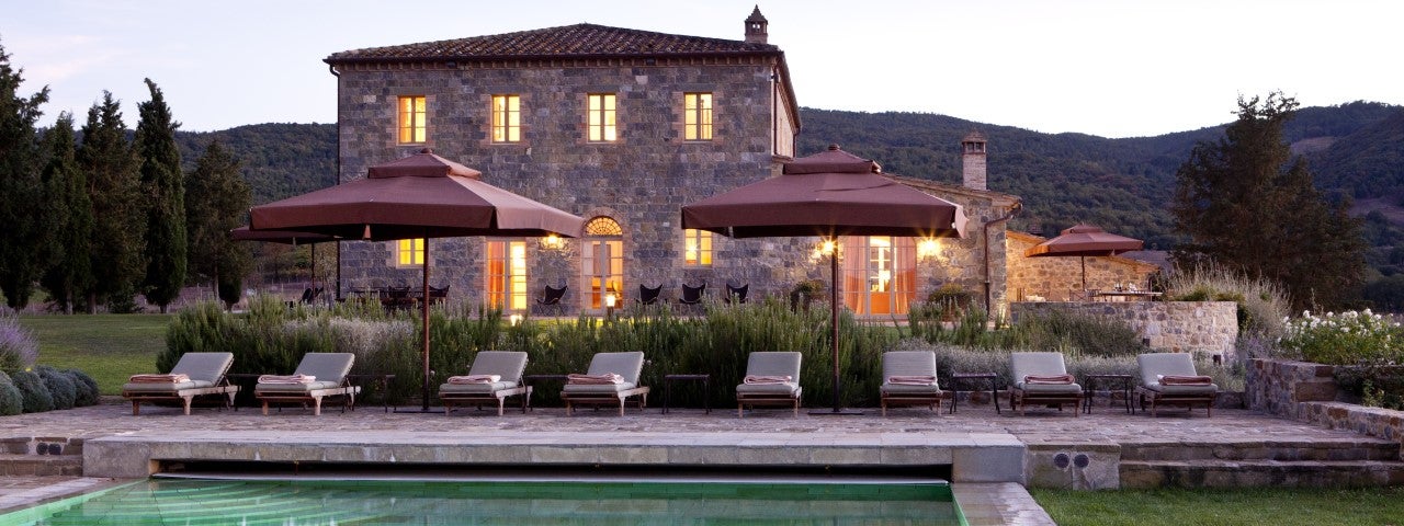 The farmhouse at Castiglion del Bosco, sitting behind its stone-walled pool and sun loungers.