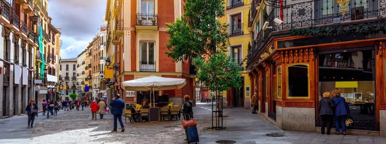 Locals and tourists are walking through a traditional, cosy street in Madrid, Spain