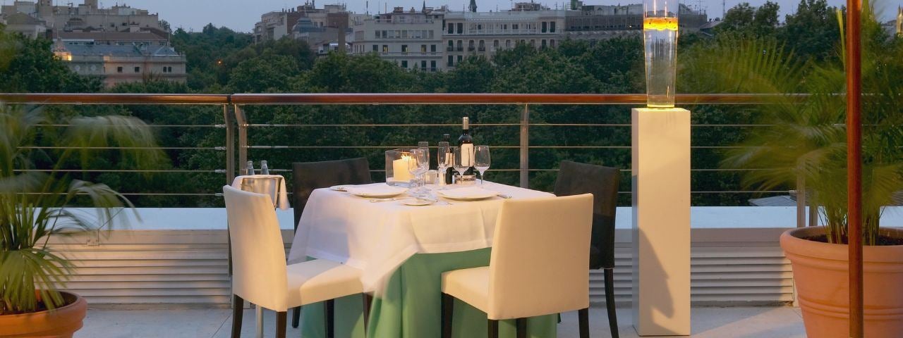 Dinner table for two on a roof terrace with a Madrid view background