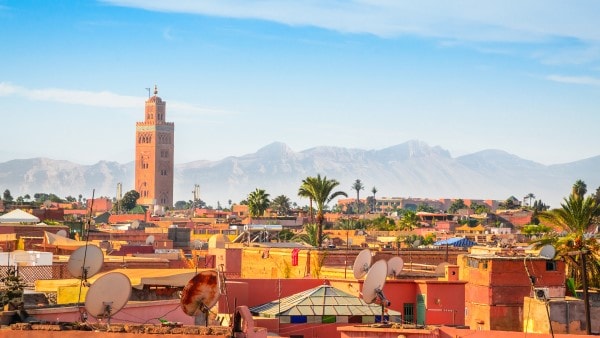 The skyline of Marrakech with nearby mountains in the background. 