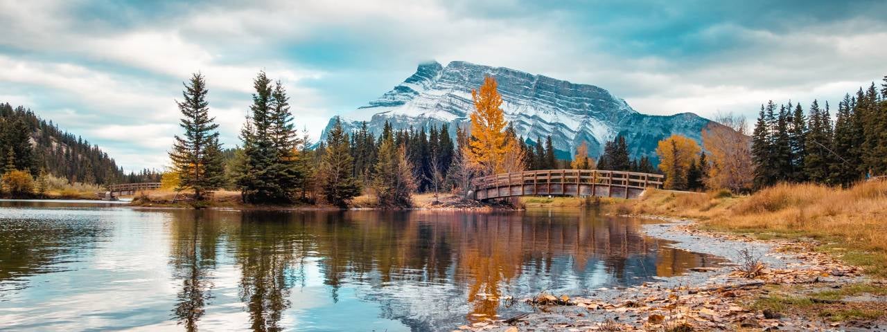 A view of a bridge over Cascade Ponds with Mount Rundle in the distance in Banff National Park.