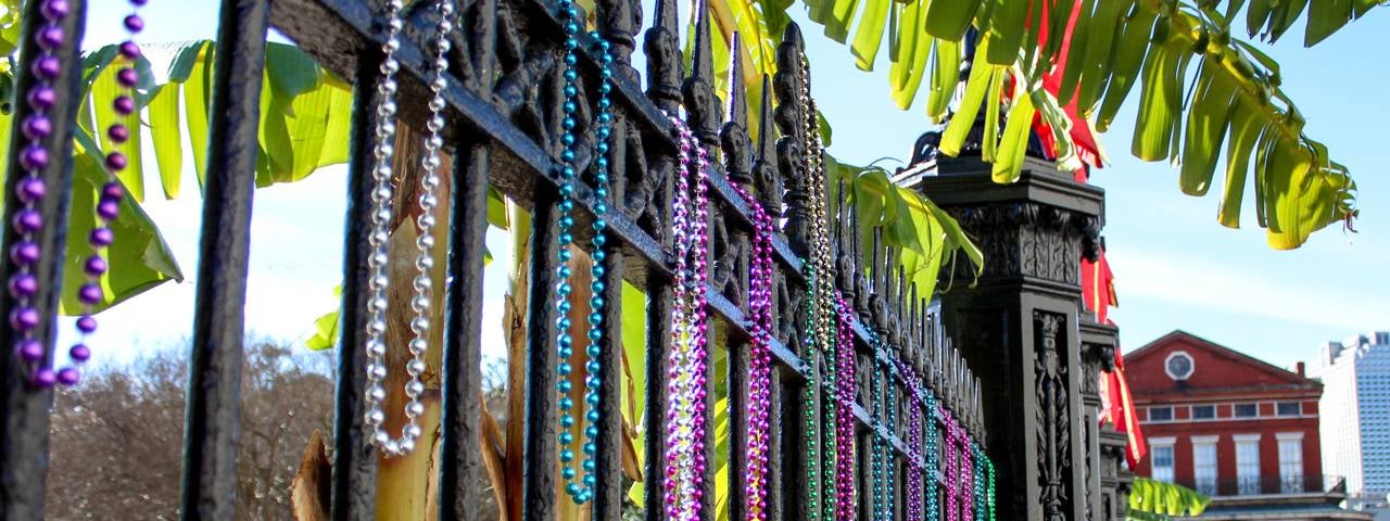 Bead necklaces hanging on a fence during New Orleans Mardi Gras.
