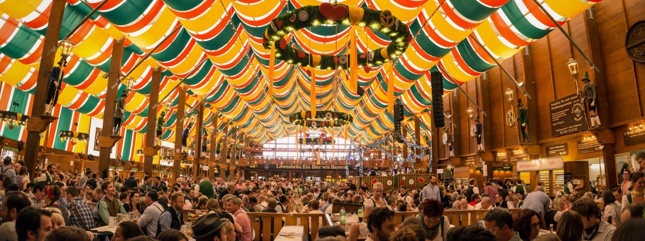 A hall packed with people celebrating Oktoberfest.
