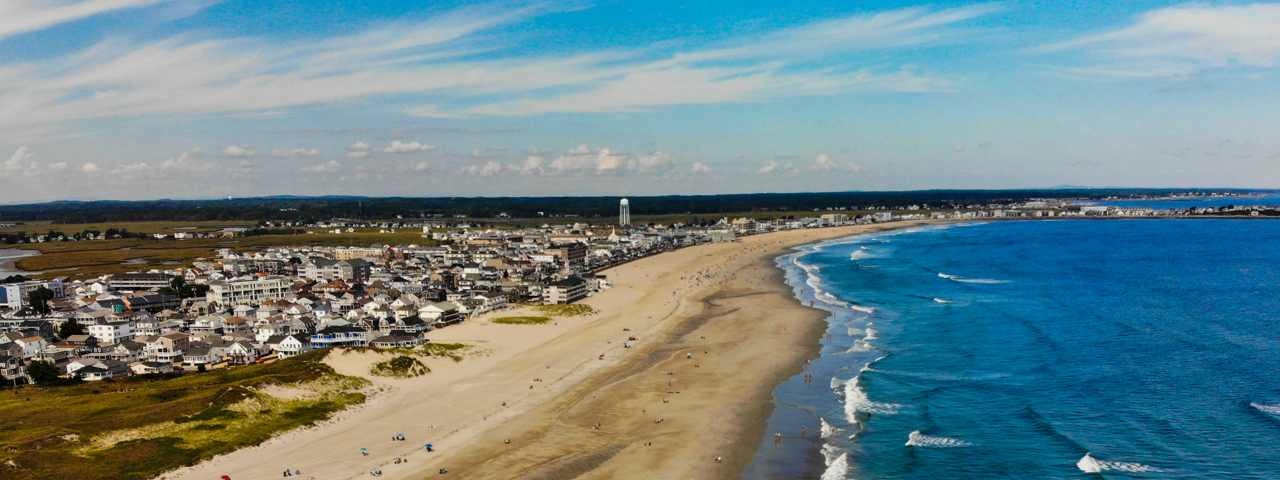 An aerial view of the Hamptons Beach with residential properties to the side of it and the ocean in the front