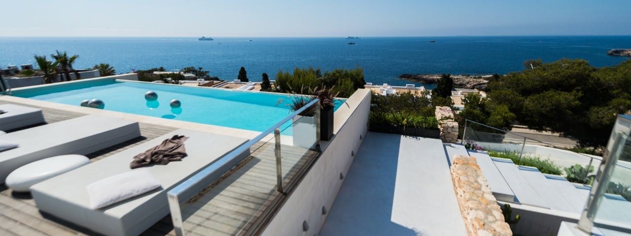 A beachfront hotel with a pool in Ibiza.