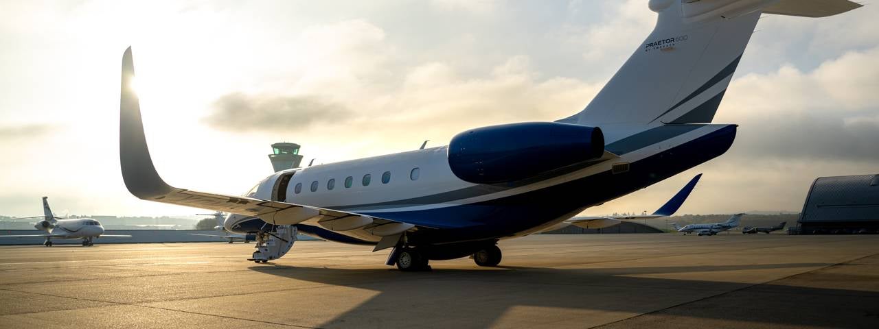 A Praetor 600 parked on the tarmac with its stairs down.