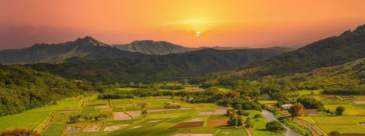 Sunset over fields and mountains in the interior of Kauai, Hawaii.