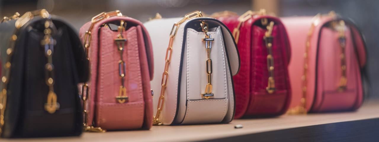 A line of purses in a shop window in Paris.