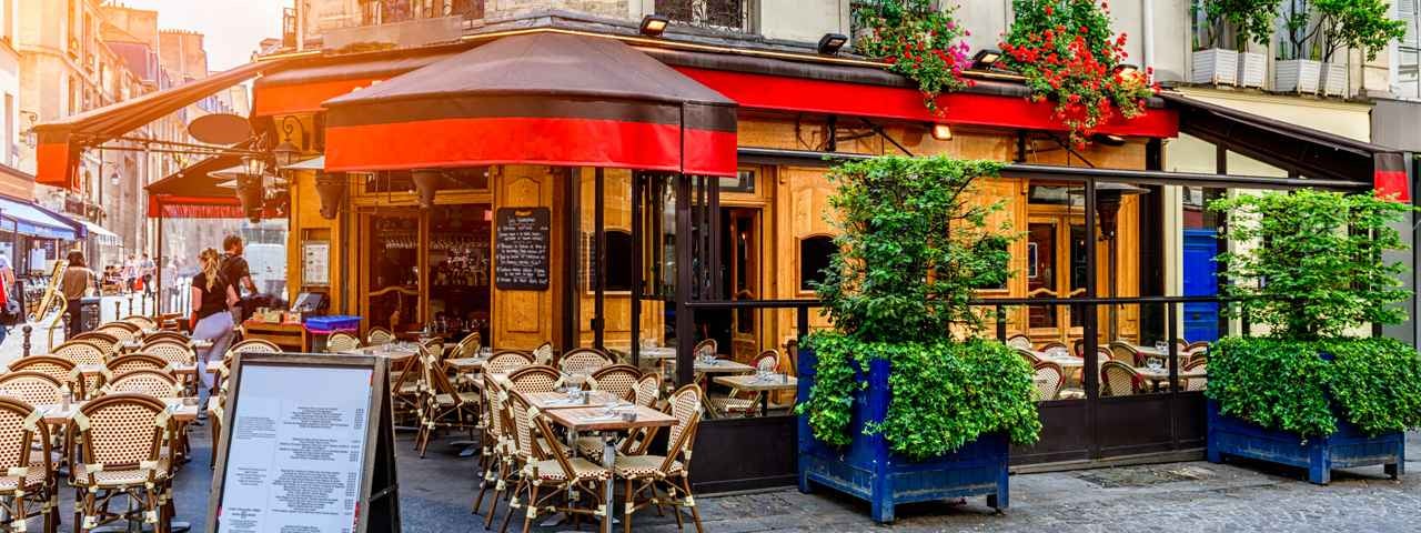 Curbside cafes and restaurants along a quaint Parisian road.