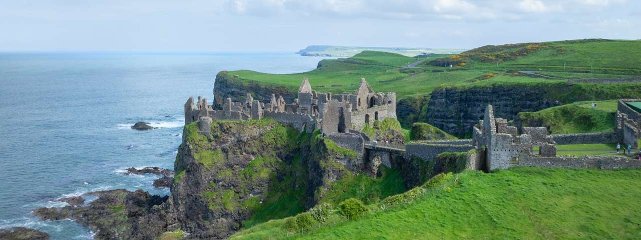 Dunluce Castle standing dramatically atop a seaside cliff.