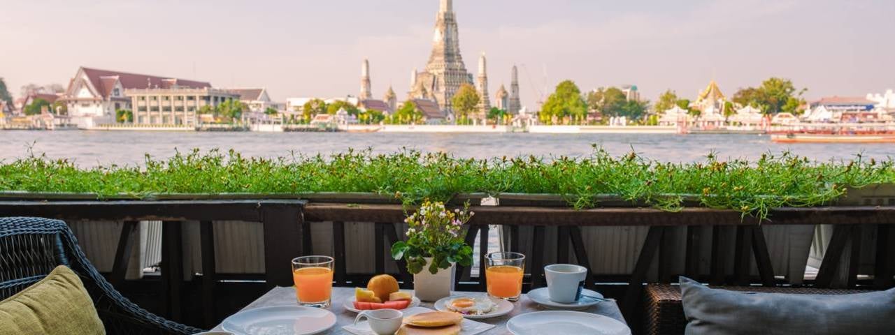 A restaurant with a view of the nearby Wat Arun temple in Bangkok.