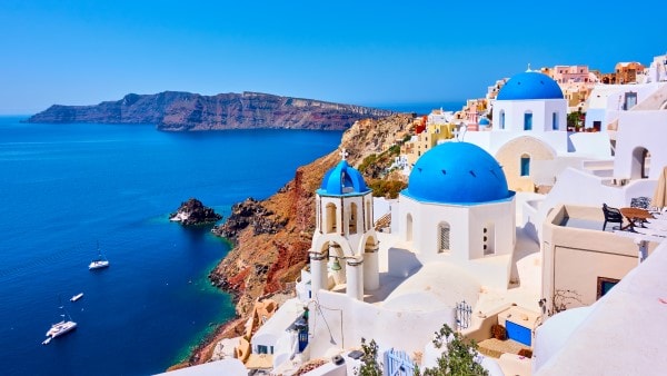 A view of the Mediterranean and the iconic white and blue architecture near the sea on the island of Santorini.