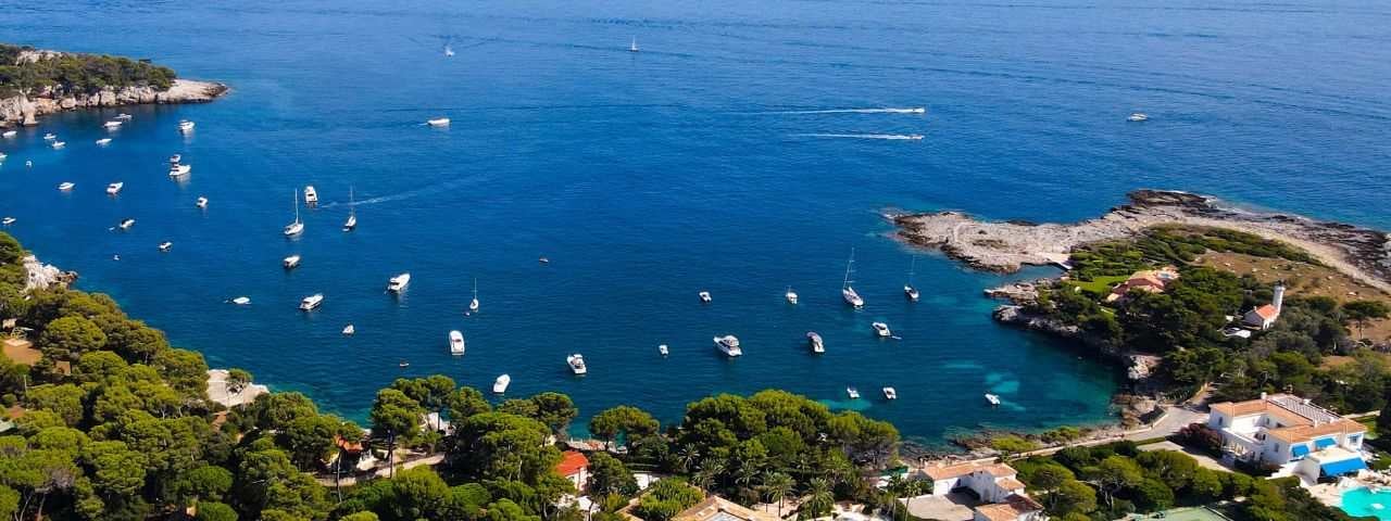 Drone view of Côte d’Azur showing a rocky beach near a coastal path on the Cap d'Antibes, Antibes, France. 