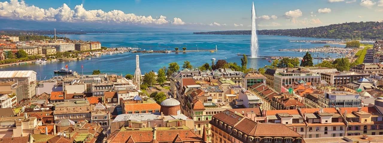 An elevated view of the Geneva city centre and the famous Jet d’Eau fountain spraying high into Lake Geneva.