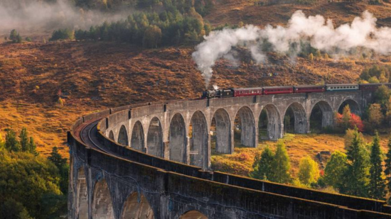 A steam train traveling along the Glenfinnan Viaduct, which features in the Harry Potter movies.