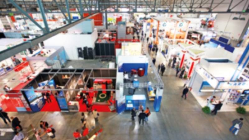 The inside of a convention hall with various company booths.