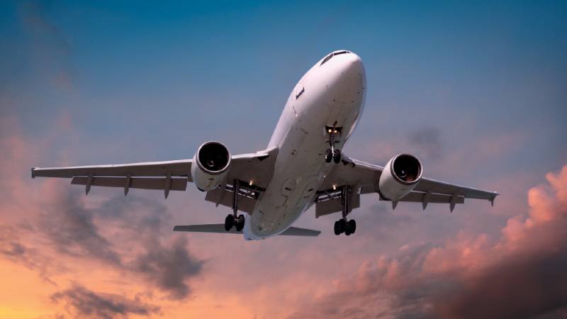 A plane with its landing gear down comes in to land.