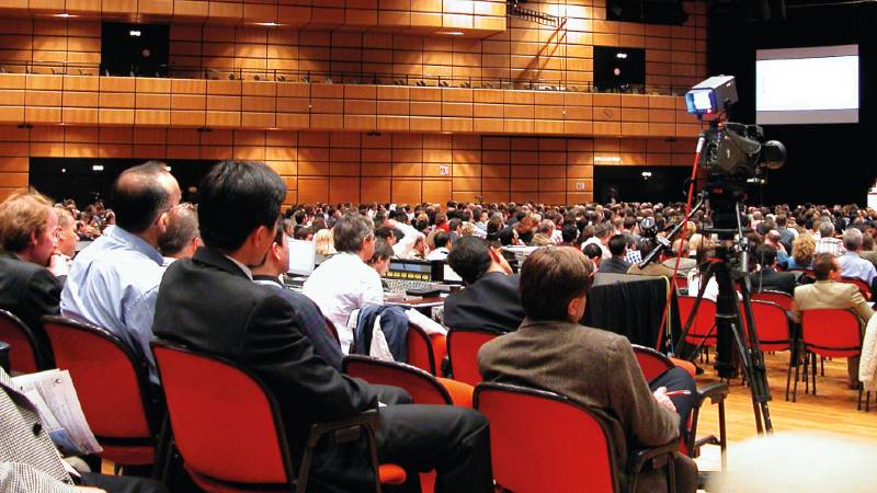 An auditorium filled with people attending a presentation.