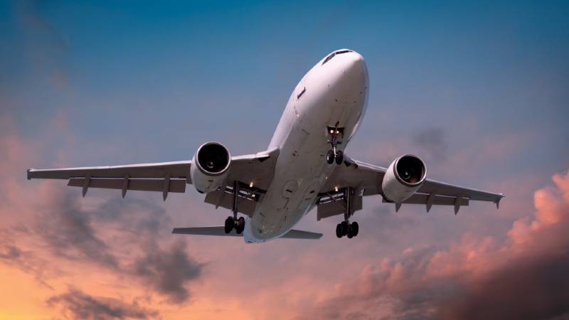 A passenger plane coming in to land with its landing gear out.