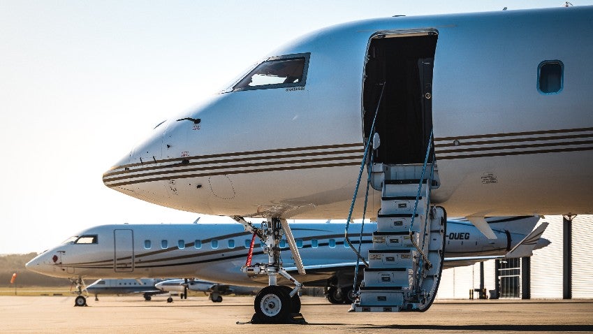 A private jet on a runway with low-lying clouds in the background.