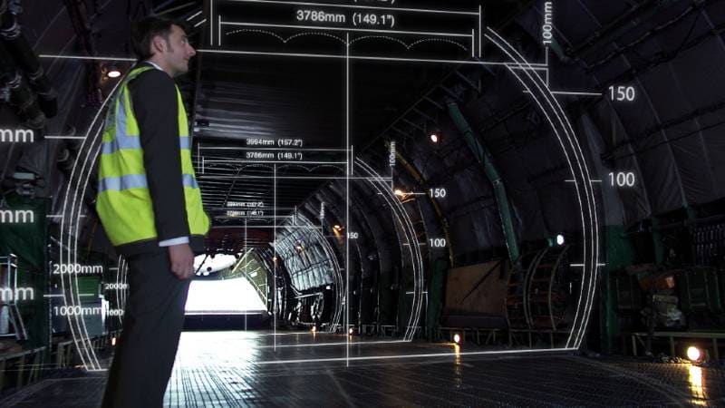 A crew member calculating the interior dimensions of a cargo hold.