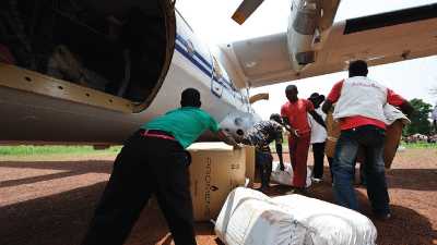 Humanitarian aid crews offloading supplies from a cargo plane.