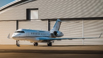 A private jet parked outside a hangar.