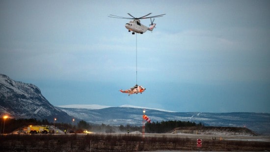 A Mil MI-26 helicopter airlifting a stranded Sea King helicopter in the Arctic Circle.